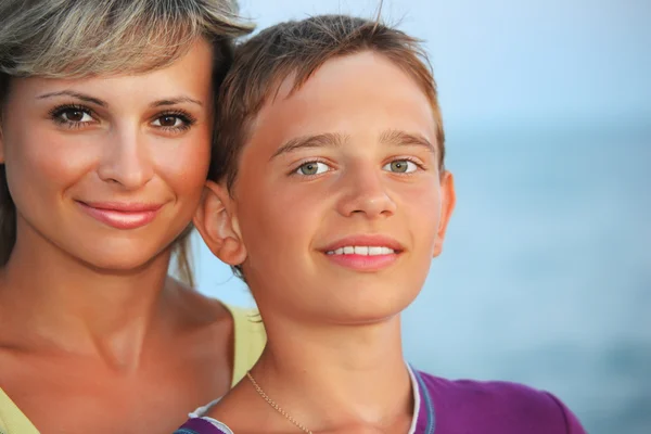 Niño sonriente y mujer joven en la playa por la noche —  Fotos de Stock