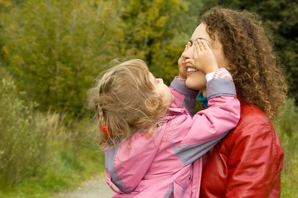 Genç bir kadın ve küçük kızı bahçede oynarken, kızın gözlerini kapatır — Stok fotoğraf