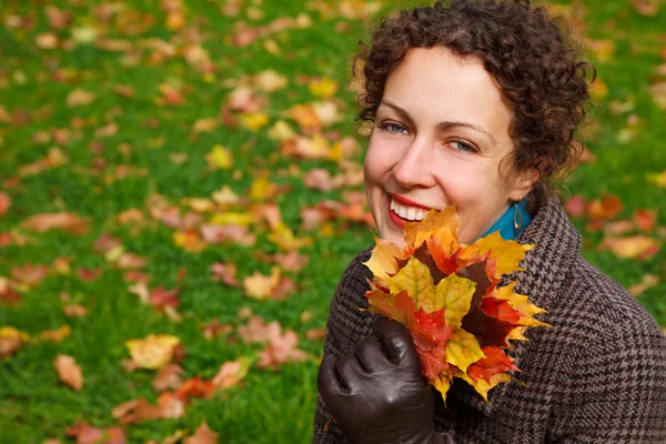 Dívka s hromadou listí v parku — Stock fotografie