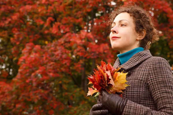 Flicka med massa löv i parken — Stockfoto