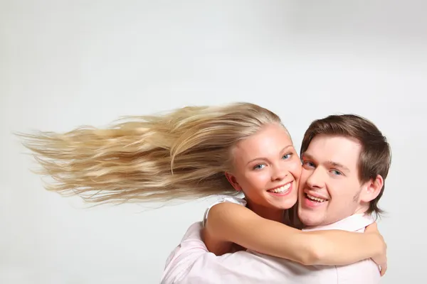 Girl with flying hair embraces young man — Stock Photo, Image