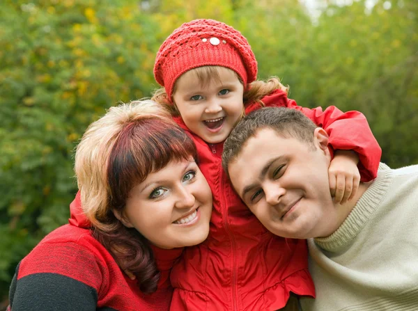 Married couple and little girl in park in autumn — Stock Photo, Image