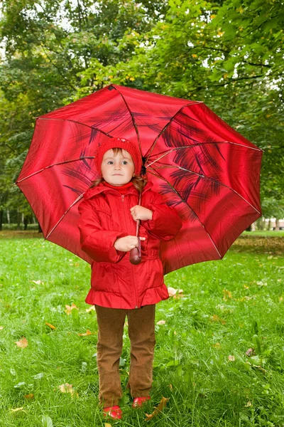Little girl with umbrella in park — Stock Photo, Image