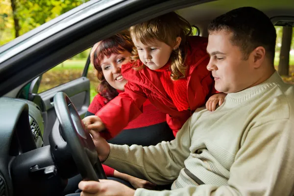 Married couple and little girl sit in car in park — Stock Photo, Image