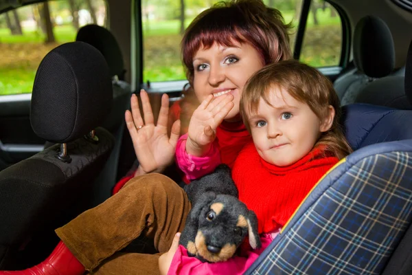 Woman and little girl Greeting to wave hands in car in park — Stock Photo, Image
