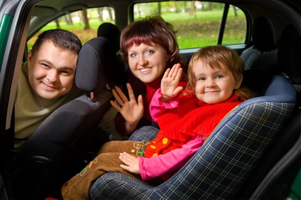 Ehepaar und kleines Mädchen begrüßen sich und winken im Auto — Stockfoto