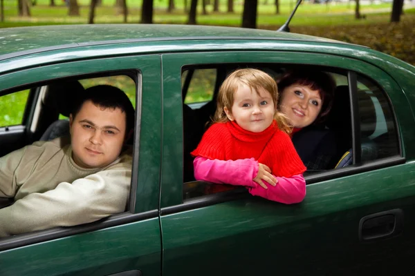 Pareja casada y niña se sientan en el coche en el parque —  Fotos de Stock