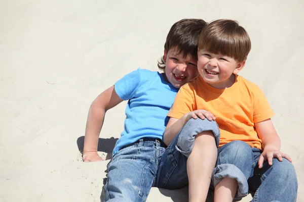 两个孩子坐在沙滩上 — 图库照片