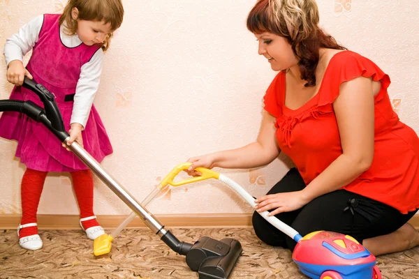 小さな女の子と女性掃除カーペット — ストック写真