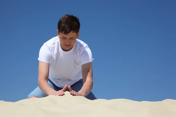 Хлопець грає в піску проти блакитного неба — стокове фото