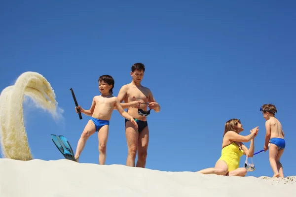 Ouders met kinderen jurk vinnen en onderwater maskers op zand — Stockfoto