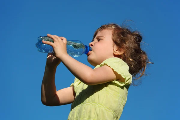 Niña bebe agua de botella de plástico contra el cielo azul —  Fotos de Stock