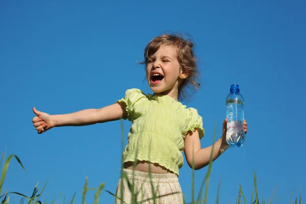 Menina gritando na grama com garrafa de plástico com água — Fotografia de Stock