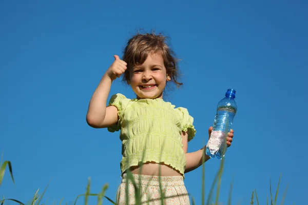 Menina na grama com garrafa de plástico com água mostra gesto por fi — Fotografia de Stock