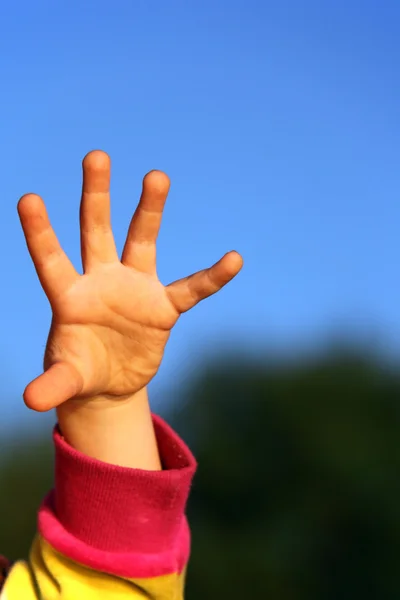 Dětská ruka proti obloze — Stock fotografie