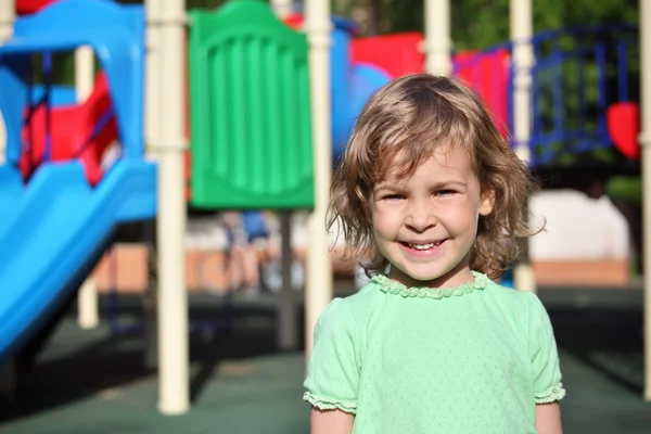 Pequena menina sorridente no parque infantil — Fotografia de Stock