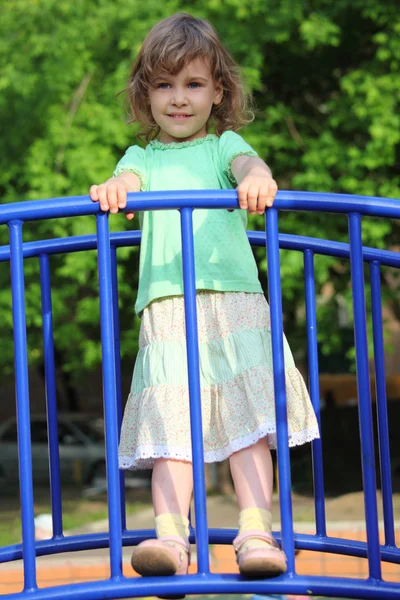Menina fica na ponte no parque infantil — Fotografia de Stock