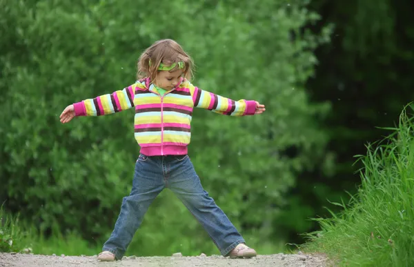 Маленькая девочка делает гимнастику в парке — стоковое фото