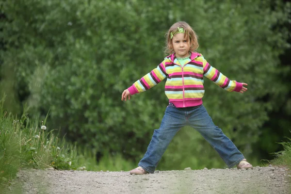 Маленькая девочка делает гимнастику в парке — стоковое фото