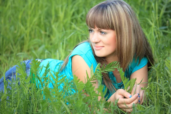 Mladá kráska dívka leží v trávě — Stock fotografie