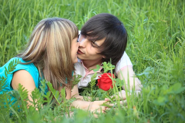 Mladá dvojice líbat v trávě — Stock fotografie