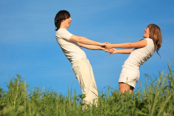 Girl and guy stand on grass having joined hands — Stock Photo, Image