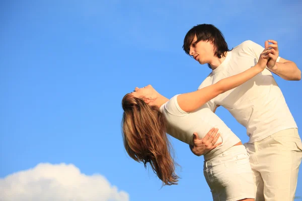 Guy holds girl for waist against sky — Stock Photo, Image