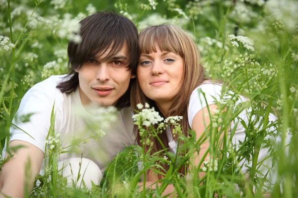 Mladá dvojice sedí v trávě — Stock fotografie