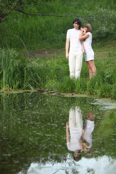 双年轻站立在池塘的银行 — 图库照片