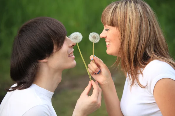 Genç çifti dandelions ellerinde wit — Stok fotoğraf