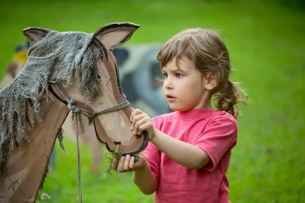 Kız ve oğlan bir ahşap hayvan besleme — Stok fotoğraf