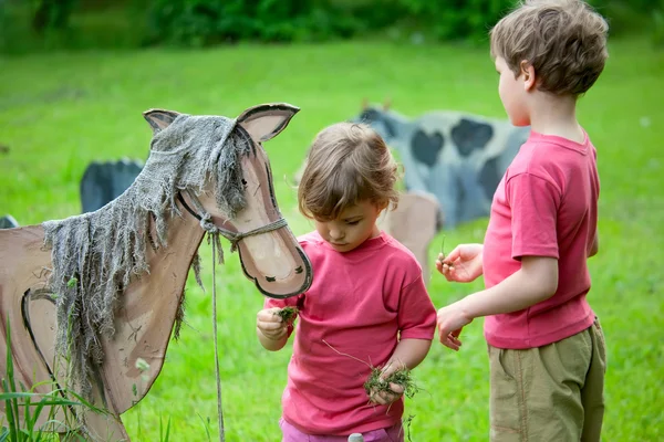 少女と少年木製の動物の飼料 — ストック写真