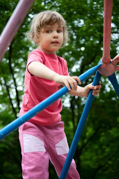 Маленька дівчинка на трубах на дитячому майданчику — стокове фото