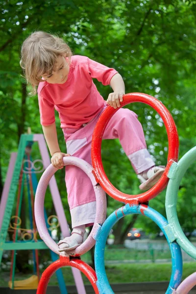 Menina em tubos no parque infantil — Fotografia de Stock