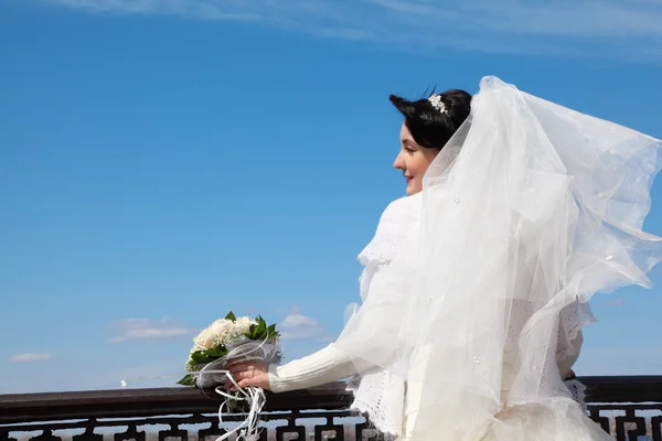 Braut mit Blumenstrauß an Brüstung — Stockfoto
