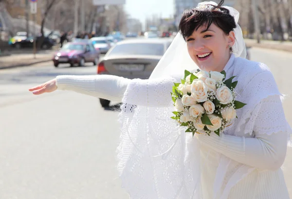 Невеста на улице останавливает автомобиль — стоковое фото