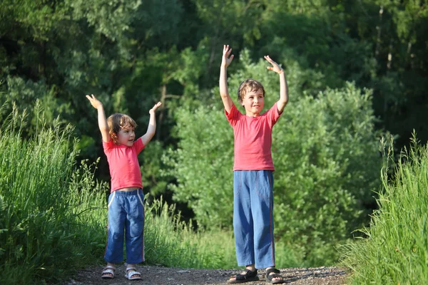 Chłopiec i dziewczynka zrobić gimnastyczne w parku — Zdjęcie stockowe