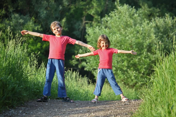Chłopiec i dziewczynka zrobić gimnastyczne w parku — Zdjęcie stockowe