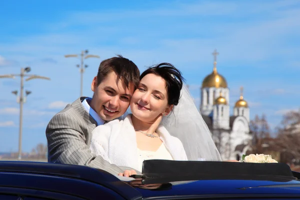 Bride with fiance against church — Stock Photo, Image