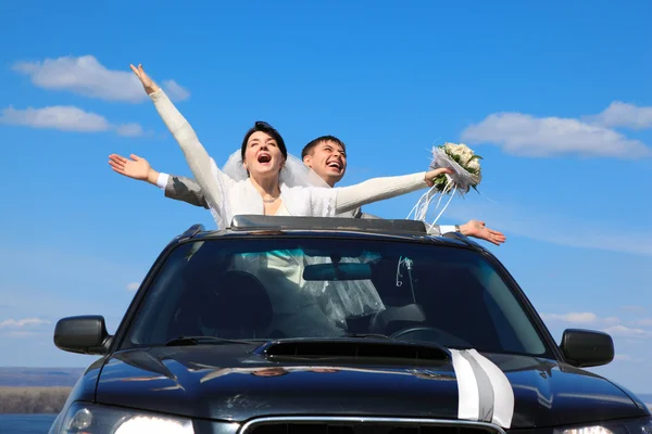 Verloofde en bruid zijn blij dat staande in auto — Stockfoto