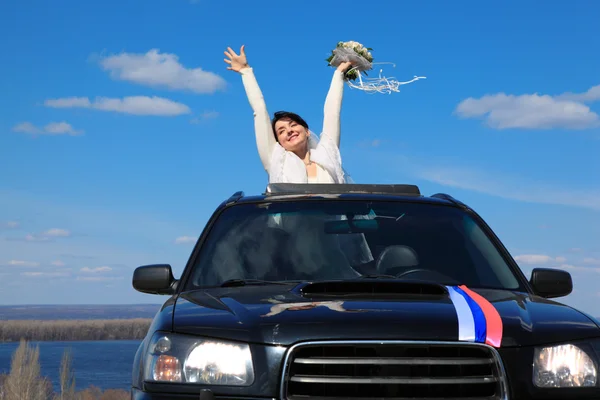 Bruid is blij dat staande in auto — Stockfoto