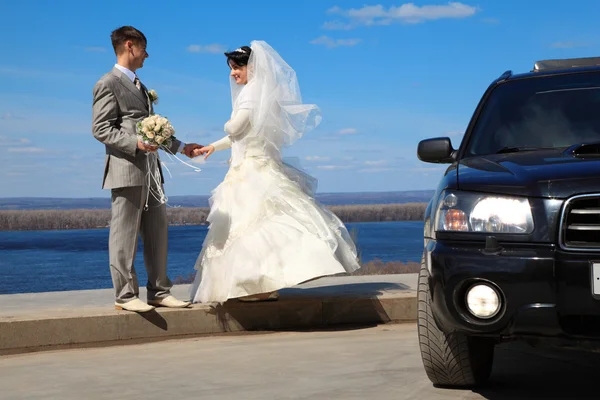 Verloofde houdt bruid voor hand buiten — Stockfoto