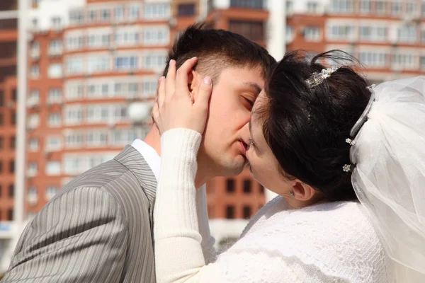 Bruden kyssar fästman utomhus — Stockfoto