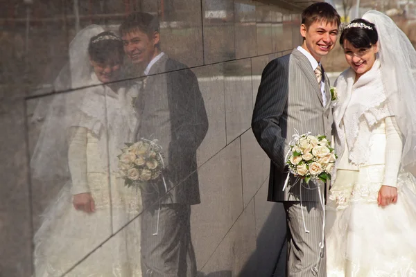Verloofde en bruid en bezinning op de muur — Stockfoto
