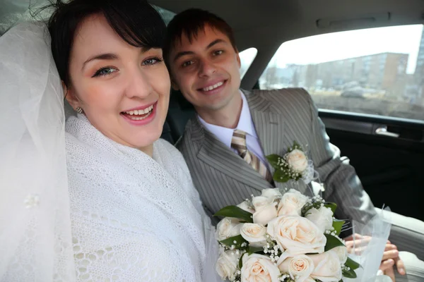 Bride with fiance in car — Stock Photo, Image