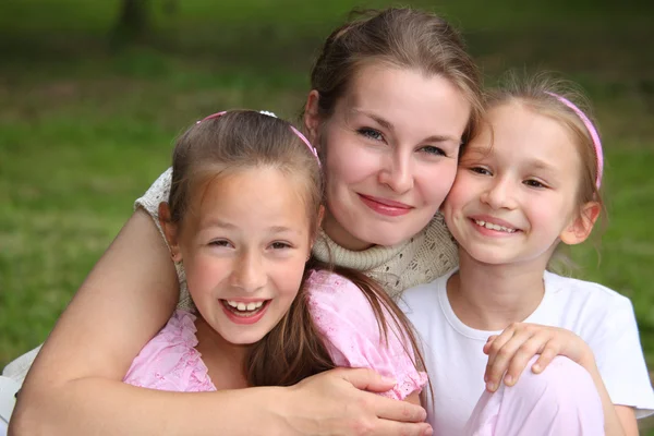 Madre abraza hijas al aire libre en verano — Foto de Stock