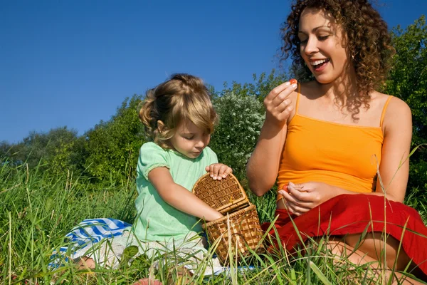 Hübsches kleines Mädchen und junge Frauen essen beim Picknick süße Kirschen — Stockfoto