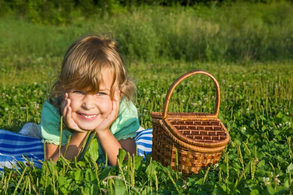 Menina bonita com cesta no prado — Fotografia de Stock