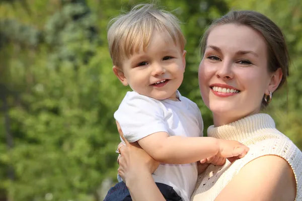 Moeder houden baby op handen buiten in de zomer — Stockfoto