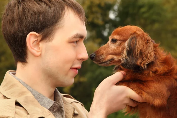 Νεαρός άνδρας και του closeup αξιολάτρευτο είδος γερμανικού κυνηγετικού σκύλου — Φωτογραφία Αρχείου